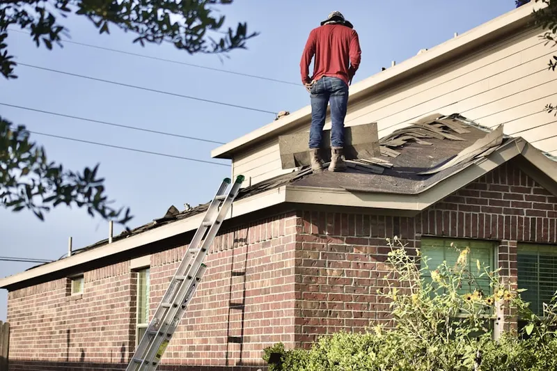 Professional roofer working on a residential roof in Sunset West
